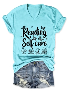 Flat lay of light blue V-neck T-shirt with Reading is Self Care print and denim shorts