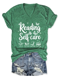 Detail of green V-neck T-shirt with Reading is Self Care print and denim shorts