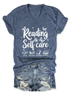 Detailed view of Reading is Self care print and roll-up sleeves on blue V-neck T-shirt