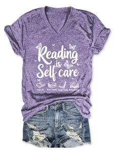 Detail of purple V-neck tee with Reading is Self Care text paired with denim shorts