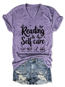 Detail of V-neck t-shirt with Reading is Self Care print paired with denim shorts