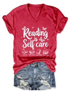 Detail of red V-neck T-shirt with 'Reading is Self Care' print and butterfly icons