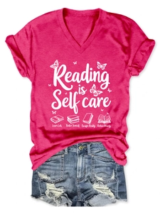 Rose red V-neck tee with Reading is Self Care print and denim shorts flat lay