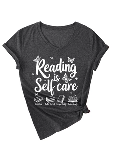Detail of V-neck charcoal t-shirt featuring Reading is Self care print and butterfly graphics