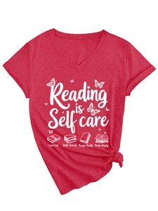 Detail of red V-neck T-shirt with 'Reading is Self Care' print and knotted hem design