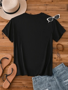 Flat lay of black crew neck t-shirt with summer vacation accessories on wood background