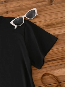 Detail of black short sleeve t-shirt stitching on wood texture with sunglasses decor