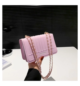 Detailed view of pink quilted PU leather bag with gold chain and fashion logo