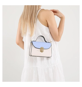Detail of a chic contrast color shoulder bag featuring a gold metal lock and blue flap cover