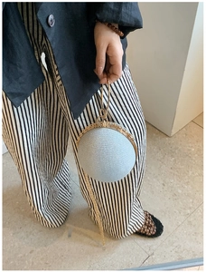Macro shot of silver-blue sphere clutch bag with gold ring handle and chain