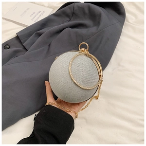 Close-up of a silver spherical evening clutch with rhinestone circular handle and gold chain