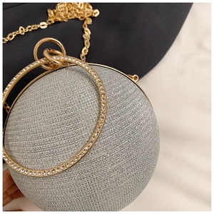 Detail of spherical evening bag featuring silver glitter finish and rhinestone ring handle
