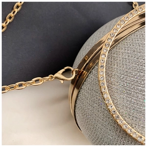 Detailed macro view of rhinestone-encrusted gold ring handle and silver glitter finish