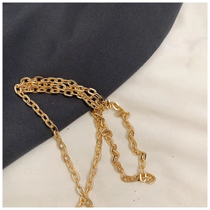 Detail of a bright golden metal chain strap with dense oval links for a luxury handbag