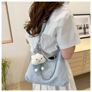Dettaglio della borsa tote in nylon azzurro con catena argento e ciondolo a nuvola