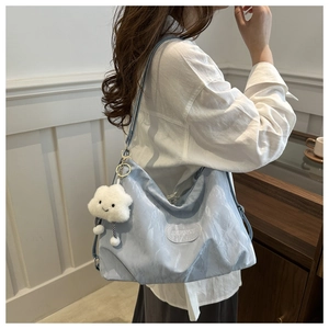 Close-up of light blue large capacity tote bag with texture and plush cloud charm