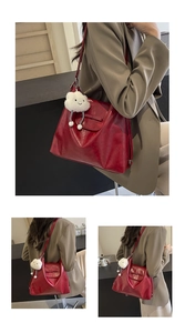 Detalle de bolso tote rojo brillante en cuero con colgante de nube blanca y gran espacio
