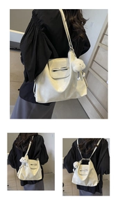 Detalle de bolso tote crema multiusos con lazo decorativo y accesorio de amuleto nube