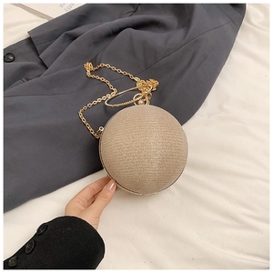 Detailed close-up of champagne gold spherical evening bag with textured glitter finish