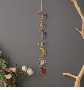 Detail of handmade suncatcher featuring moon shapes with colorful natural healing crystals