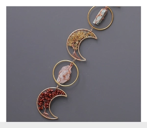 Detail of moon-shaped sun catcher with tree of life wire-wrapped natural crystal stones