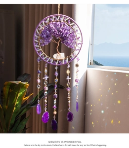 Detailed tree of life suncatcher with amethyst stones casting light on the wall