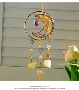 Detail of moon-shaped crystal dreamcatcher with citrine stones and golden tree of life
