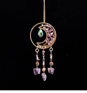Detail of moon-shaped purple crystal suncatcher with gold metal tree of life frame