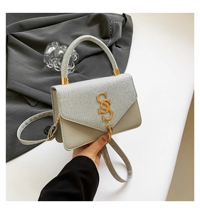 Gros plan détaillé d'un sac à main tissé avec paillettes argentées et logo doré