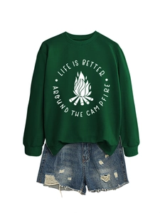 Close-up of dark green sweatshirt with campfire print tucked into ripped denim shorts