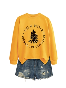 Detail of yellow sweatshirt with campfire print and distressed denim shorts flat lay