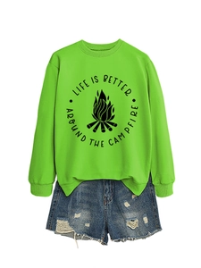 Flat lay of green campfire sweatshirt with distressed denim shorts on white backdrop