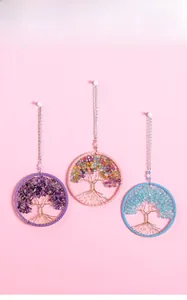 Detailed view of three colorful handmade tree of life wall hangings with natural gemstones