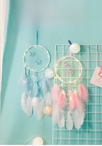 Detail of dream catcher with colorful butterflies, feathers and glowing LED fairy lights