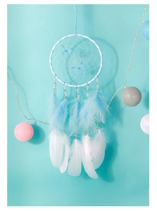 Detail of handcrafted dream catcher with blue butterflies and soft white feathers