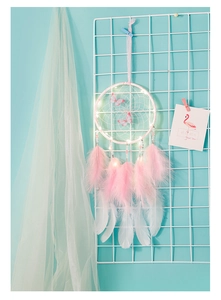 Detail of pink dream catcher with LED lights, delicate feathers and butterfly charms