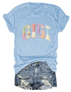Detail view of GIGI patchwork applique on a casual light blue short sleeve T-shirt