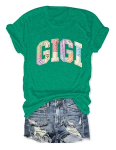 Detail of green cotton T-shirt with GIGI rainbow patchwork and distressed denim shorts