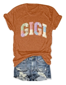 Detail of GIGI floral patch embroidery on orange cotton t-shirt with denim shorts