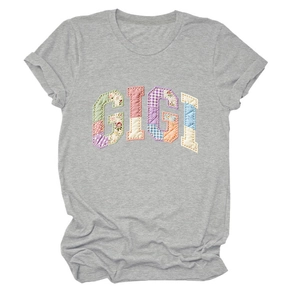 Detail of GIGI patchwork letters on a grey cotton t-shirt with rolled-up short sleeves