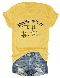 Flat lay of yellow t-shirt with UNDERESTIMATE ME slogan and distressed denim shorts