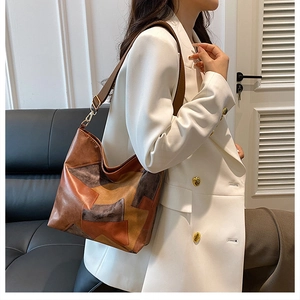 Detail of retro color-block patchwork tote bag with high-quality leather and gold hardware