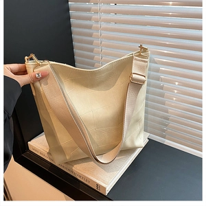 Detail of cream white large capacity shoulder bag with wide strap and gold hardware