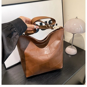 Macro detail of brown textured PU leather stitching on a minimalist large tote bag