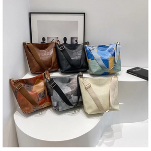 Contrast color patchwork tote bags displayed on white pedestals for daily commute
