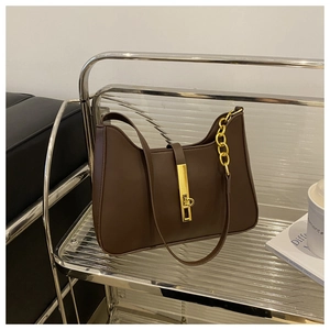 Close-up of deep brown crescent bag with gold buckle and chunky chain detail