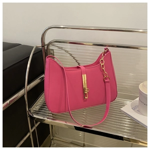Detail of rose pink leather crescent bag featuring a vertical gold metal buckle and chain strap