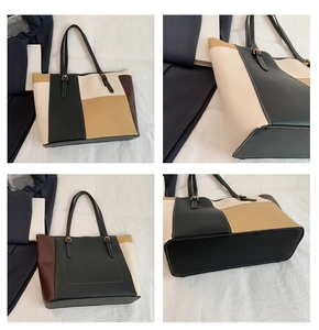 Detail view of color-block tote bag showing stitching, golden hardware, and base
