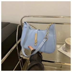 Detail of light blue crescent bag featuring golden buckle and metallic chain strap
