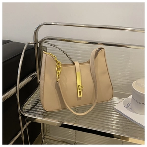 Detail of beige hobo bag showing gold buckle, thick chain, and smooth leather texture